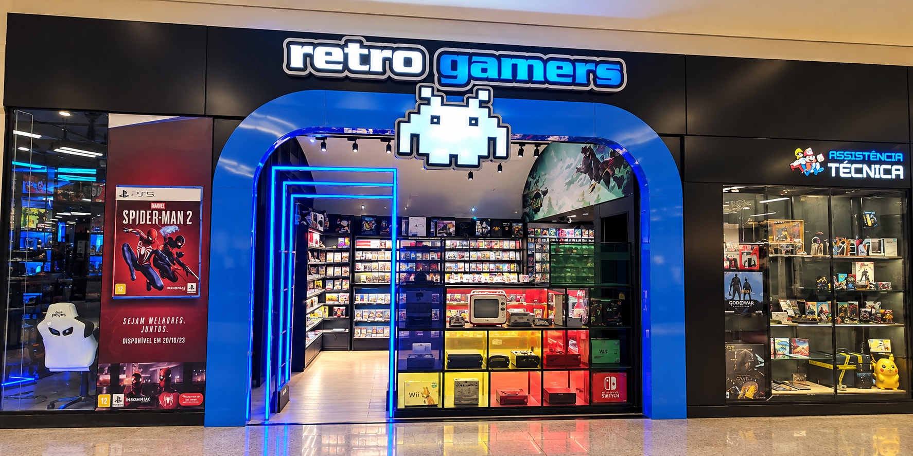 Fachada da Retro Gamers: arco azul iluminado, invader no letreiro e vitrines